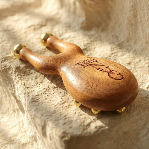 Wooden tool with gold accents on a textured stone surface