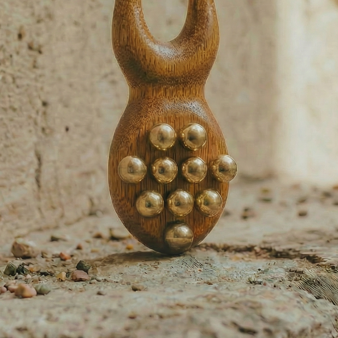 Wooden and metal acupressure tool on a stone surface